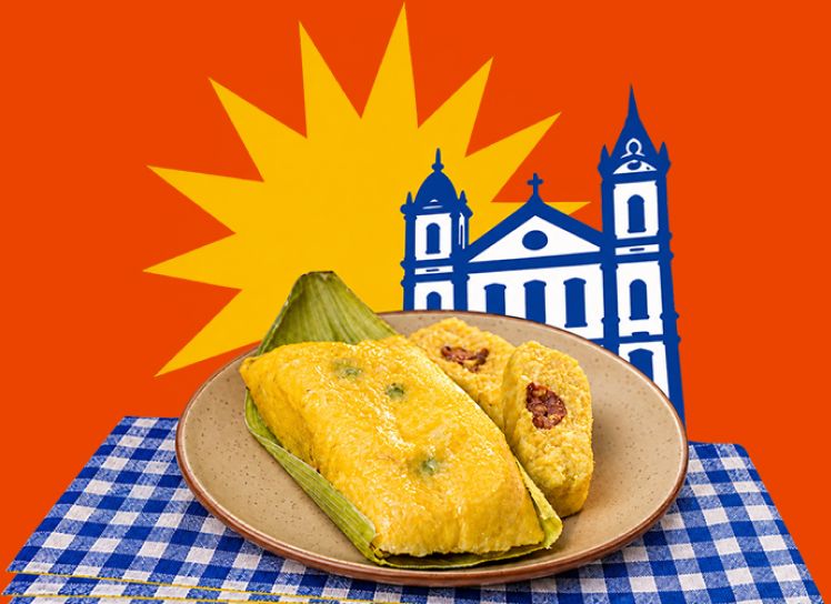 Prato de pamonhas sobre toalha xadrez, com a ilustração de uma igreja goiana ao fundo